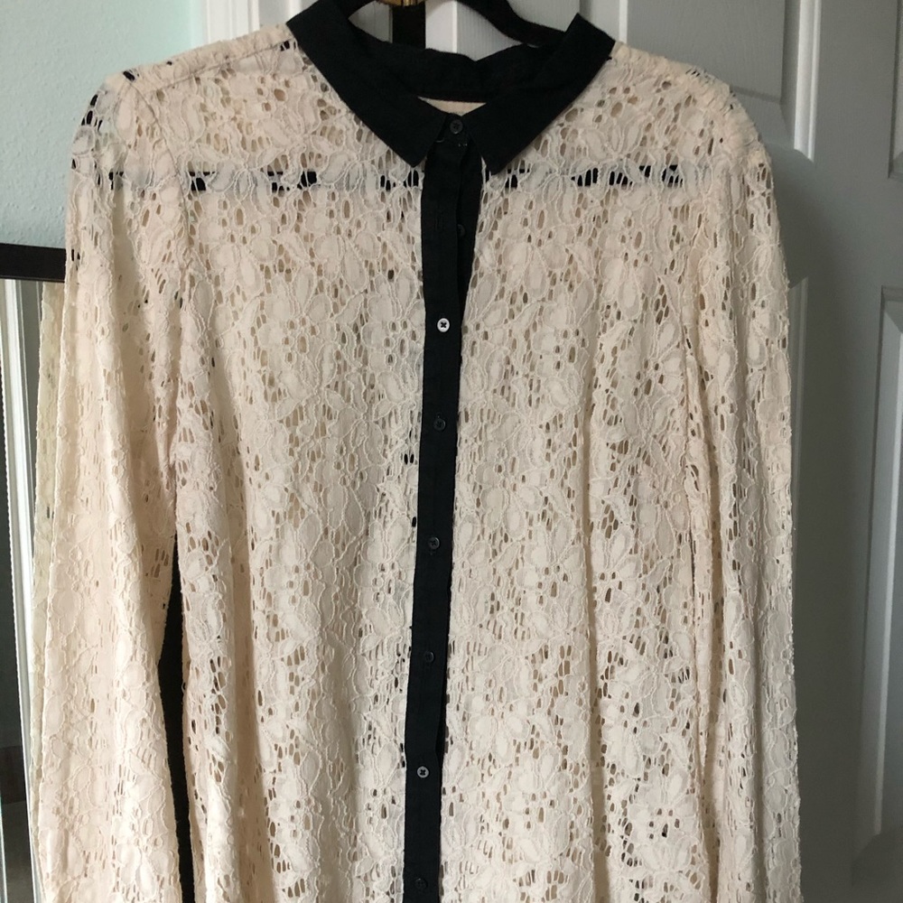 Cream lace blouse with black trim and collar.